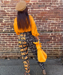 The back view of the Love Nova Graffiti Print pants with mud print on one side and the word Love printed in gold over the black and white mud print ono the other side.